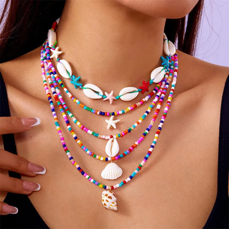Blue and coloured women's summer necklace set with starfish, shell, and conch bead pendants on beaded chains
