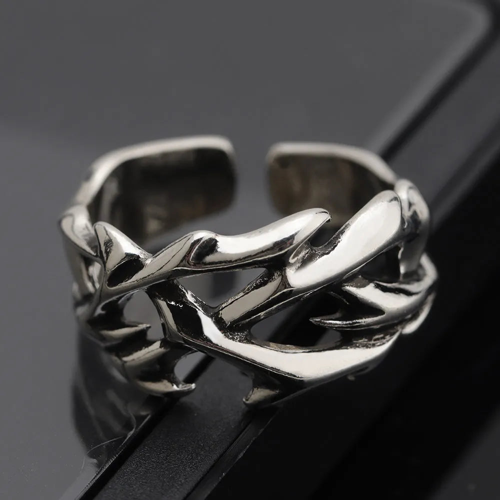 Copper geometric thorn flower ring with adjustable band on a grey background.