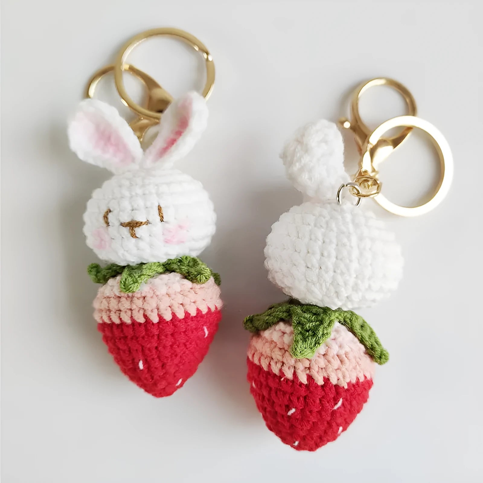 White hand-woven wire rabbit pendant with strawberry pattern attached to a key ring