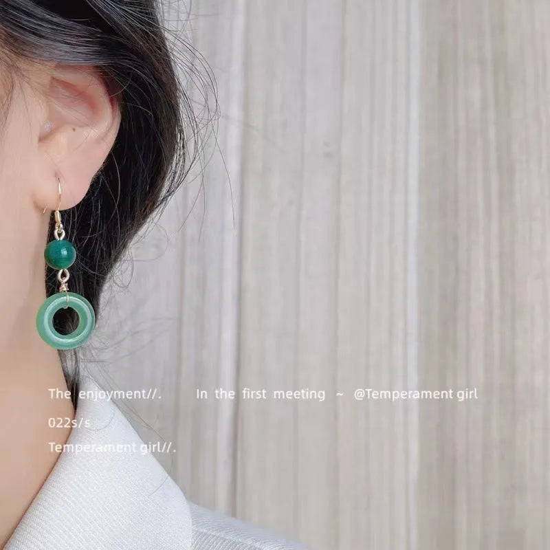 Green and gold Chinese style peace buckle shape earrings with geometric ring design.