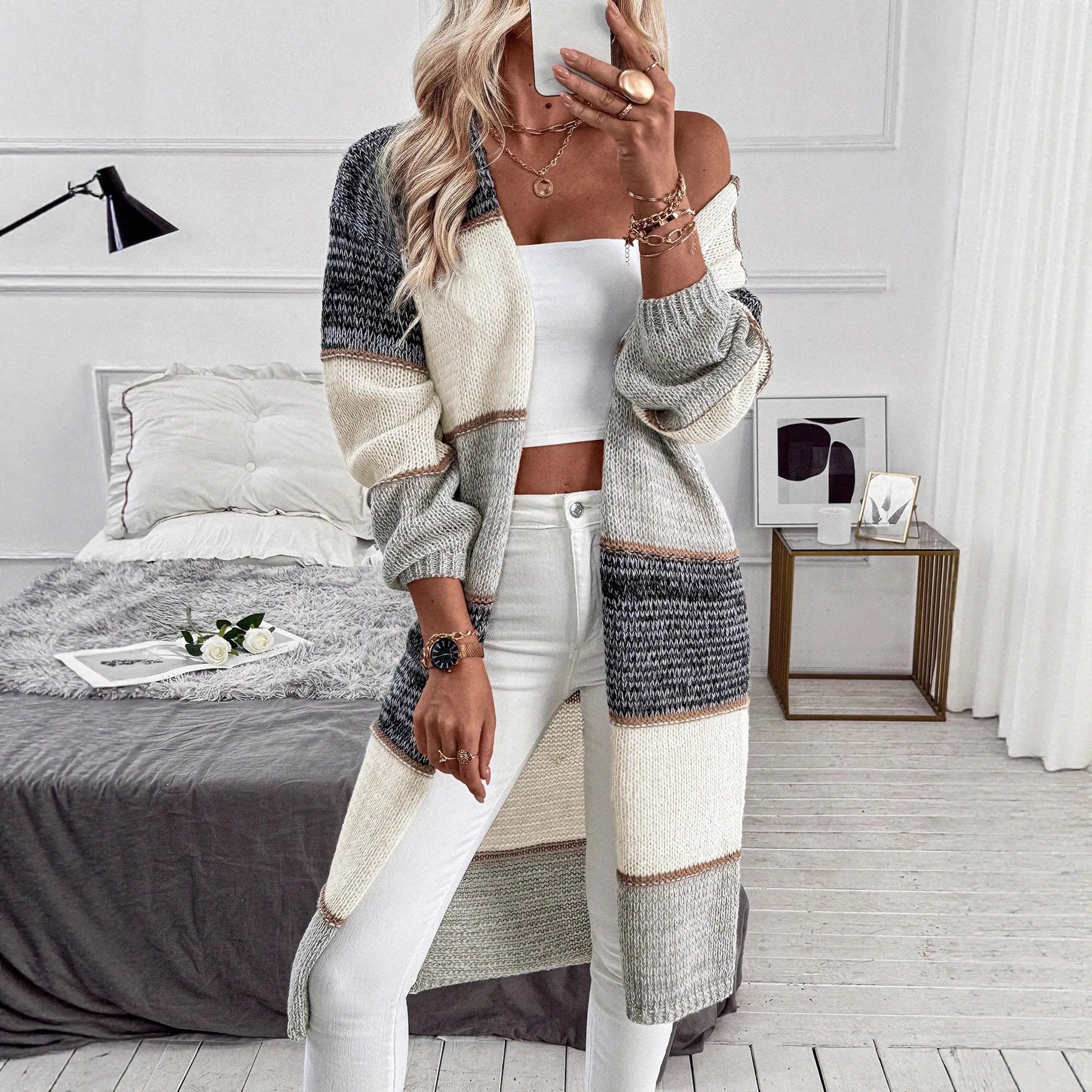 Grey loose-fit long knitted cardigan for women on a hanger, showing long sleeves and a stripe or plaid pattern.