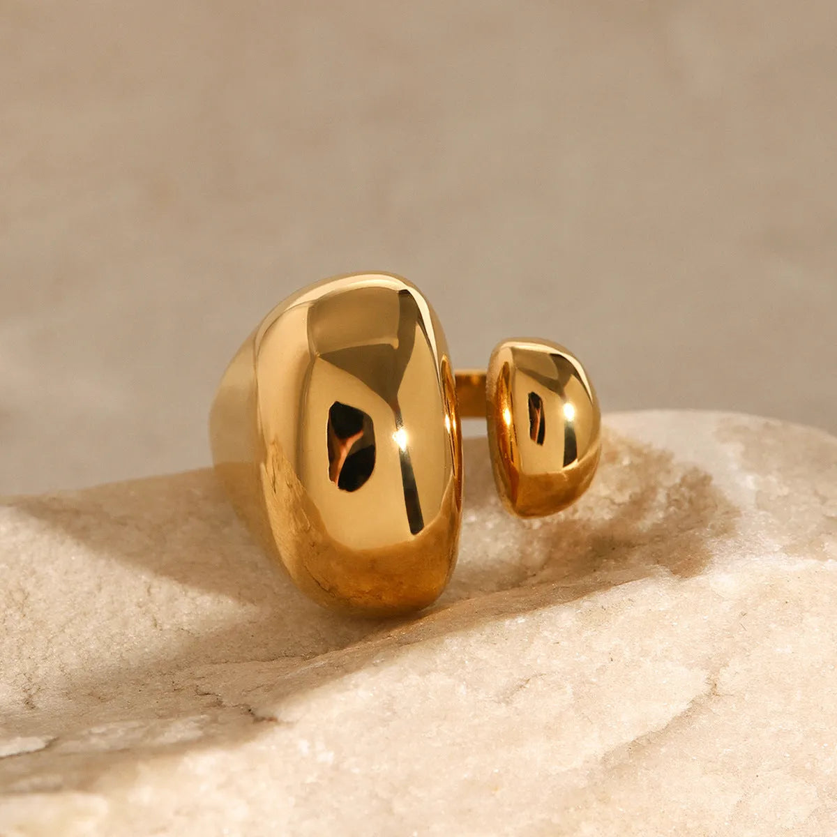 Women's geometric open ring in stainless steel with electroplated finish showing exaggerated angular design
