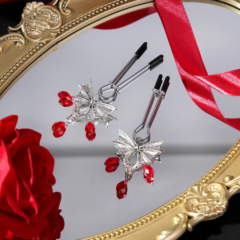 Silver bat-shaped nipple clamp with ruby detail and adjustable tension mechanism