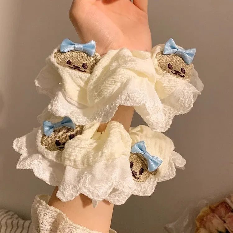 Close-up of a blue cloth hair ring with a cute bear and bow design, showing its large intestine loop style.