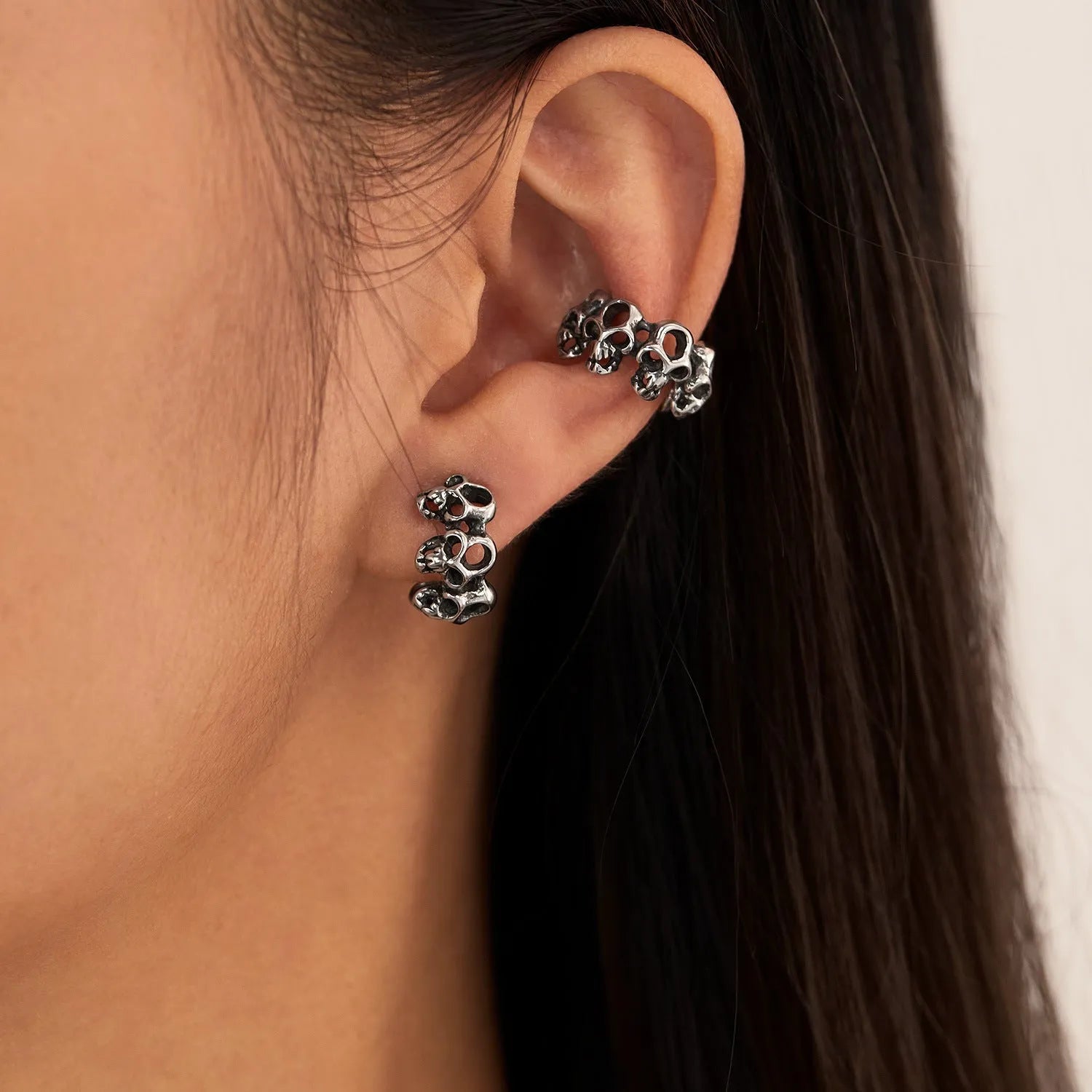 Stainless steel clip-on earrings with hollow geometric skull design in electroplated finish