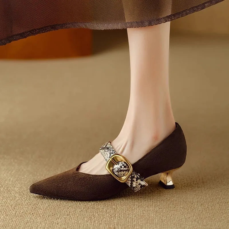 Women's black stiletto high heels with a buckle closure and pointed toe on a mid heel.