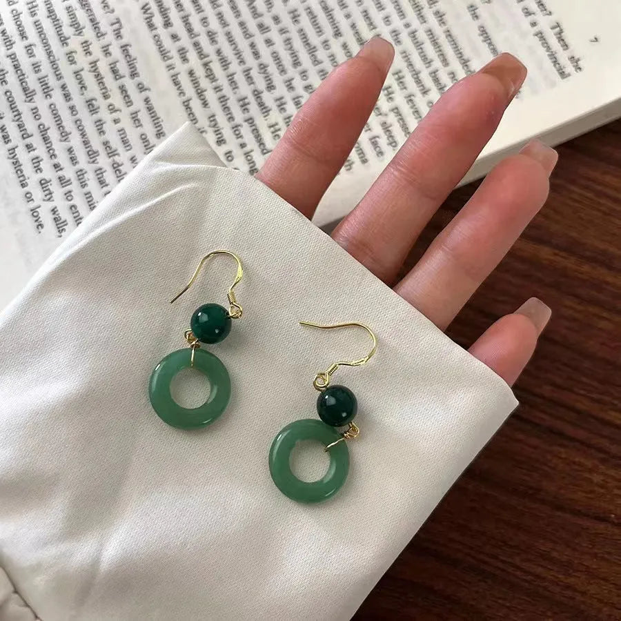 Green and gold Chinese style peace buckle shape earrings with geometric ring design.