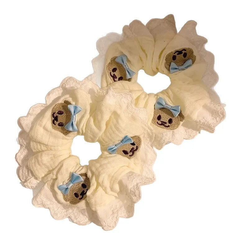 Close-up of a blue cloth hair ring with a cute bear and bow design, showing its large intestine loop style.