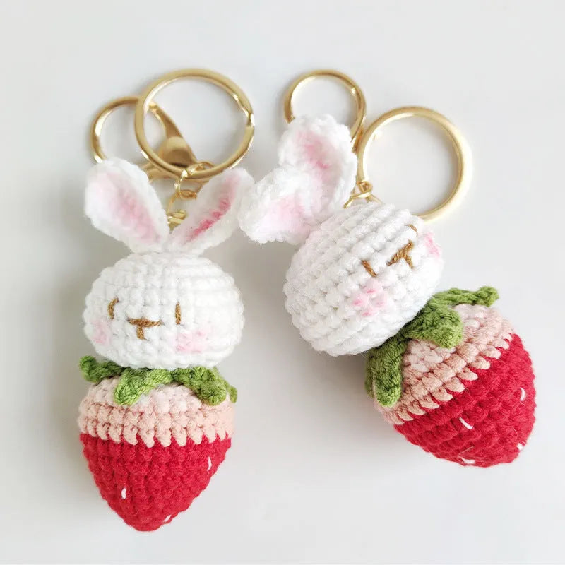 White hand-woven wire rabbit pendant with strawberry pattern attached to a key ring