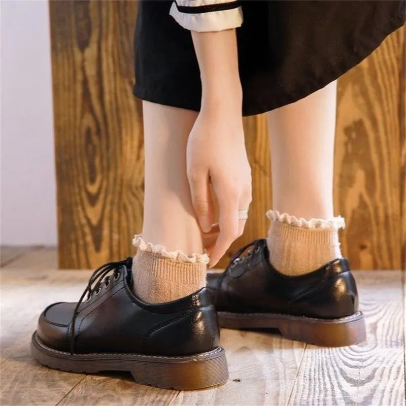 Women's black retro Mary Jane lace-up pumps with round toe and low square heel on a white background.