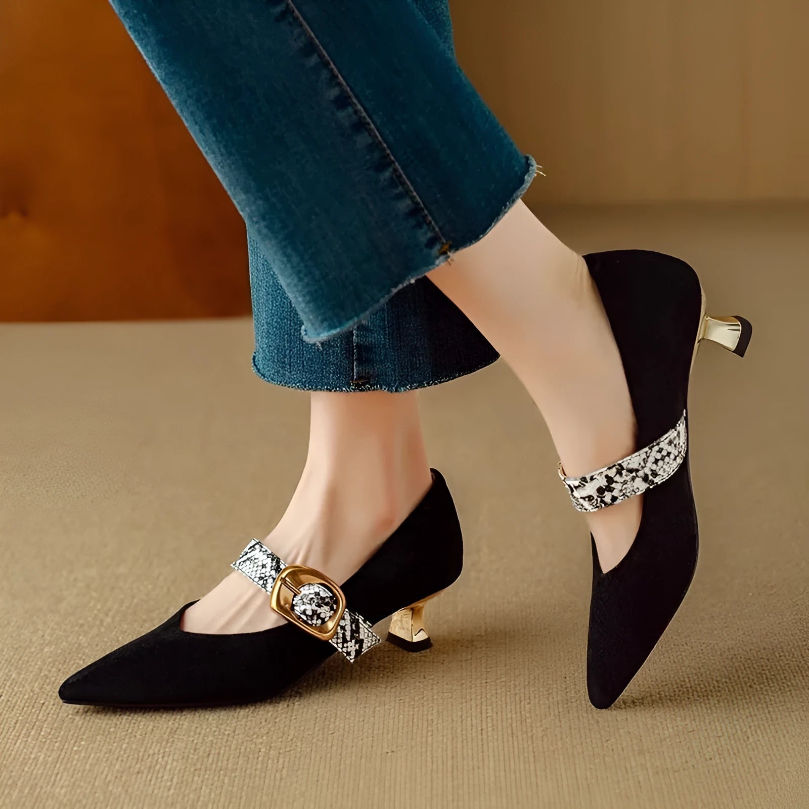 Women's black stiletto high heels with a buckle closure and pointed toe on a mid heel.