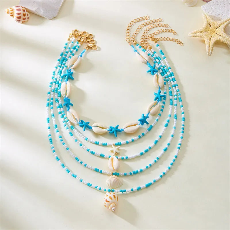 Blue and coloured women's summer necklace set with starfish, shell, and conch bead pendants on beaded chains