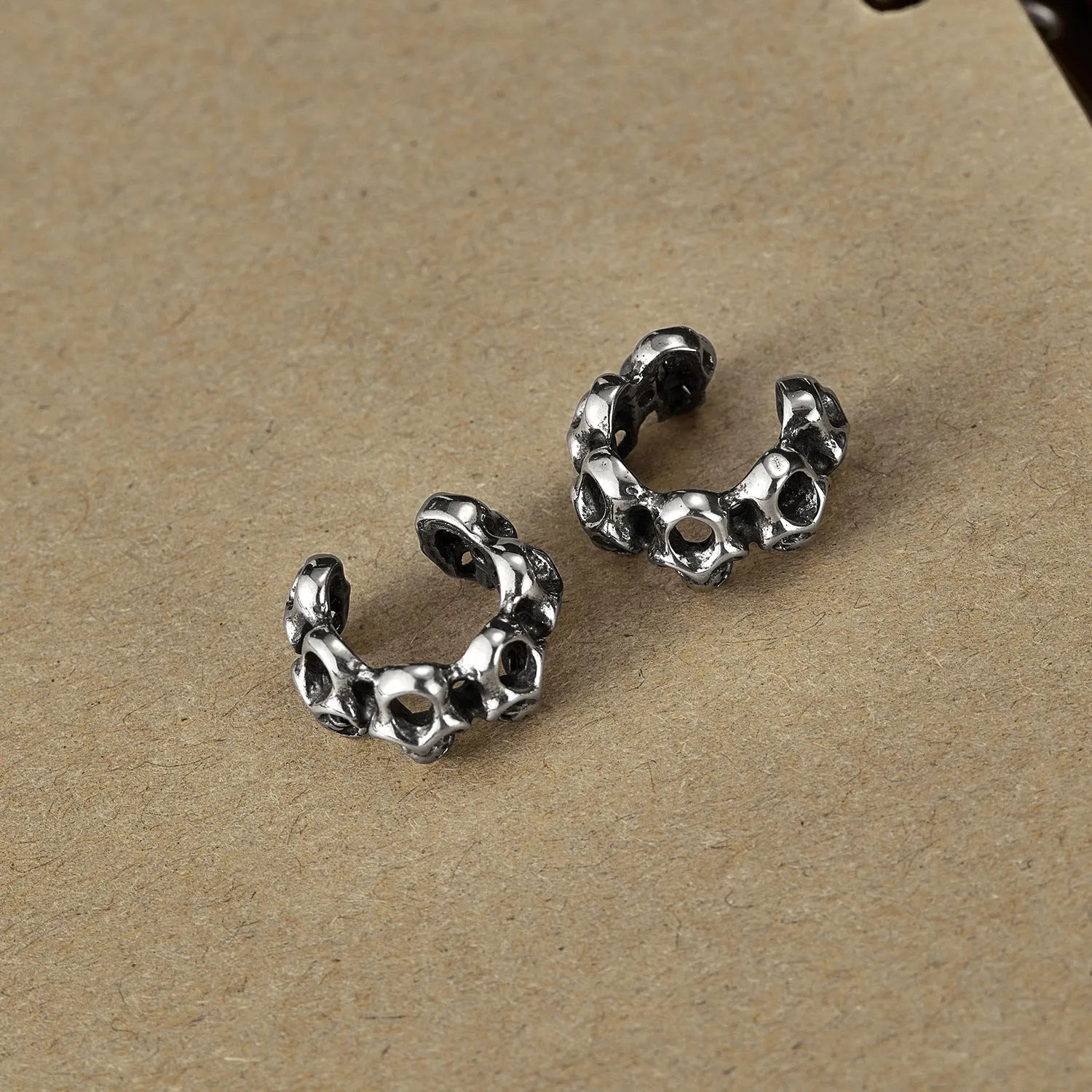 Stainless steel clip-on earrings with hollow geometric skull design in electroplated finish
