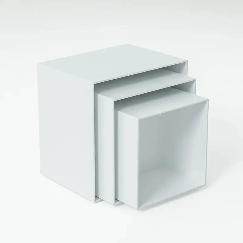 Set of six white plastic cube dessert display stands arranged on a table.