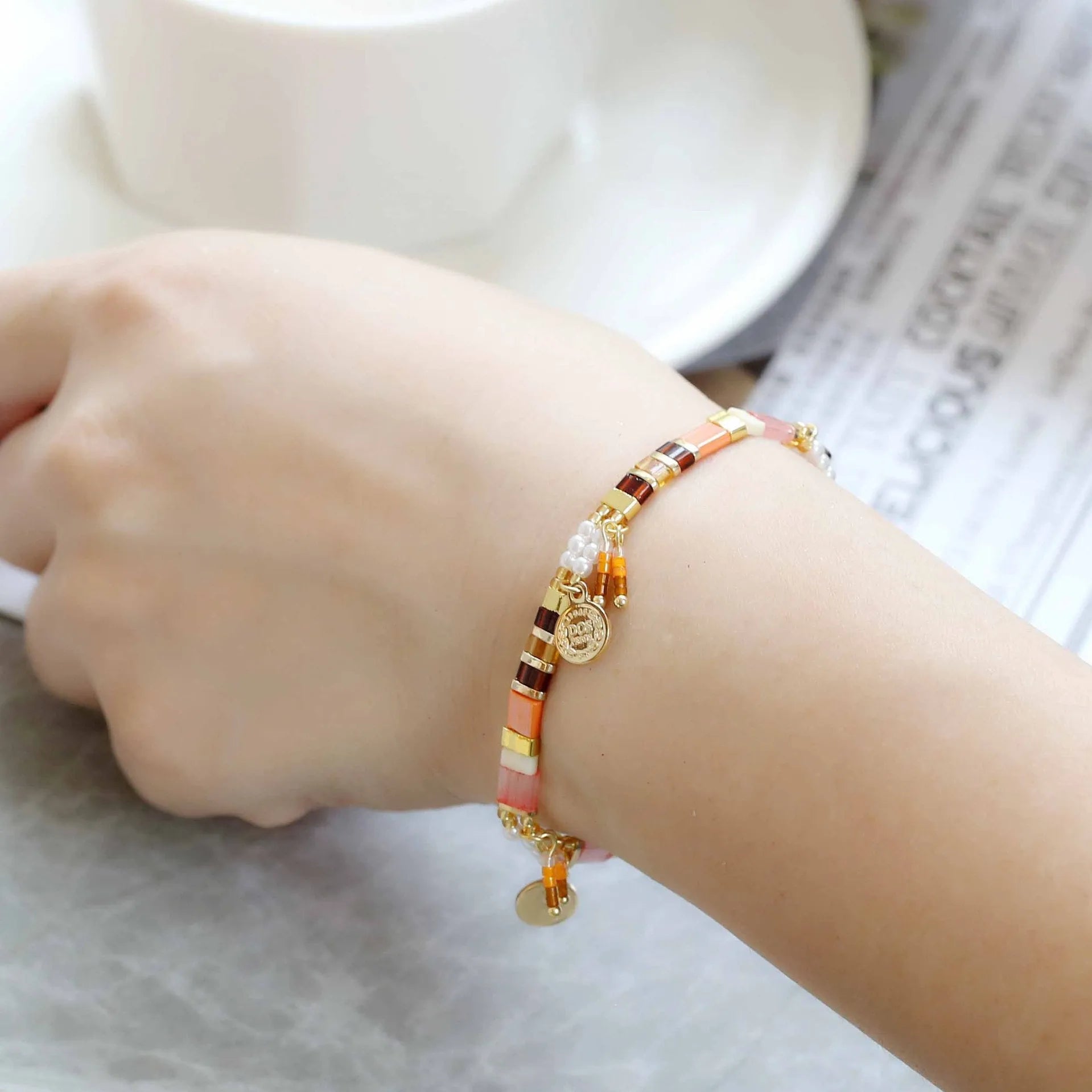 Women's imitation pearl beaded bracelet showing six pearl-lift colour variations with manual processing