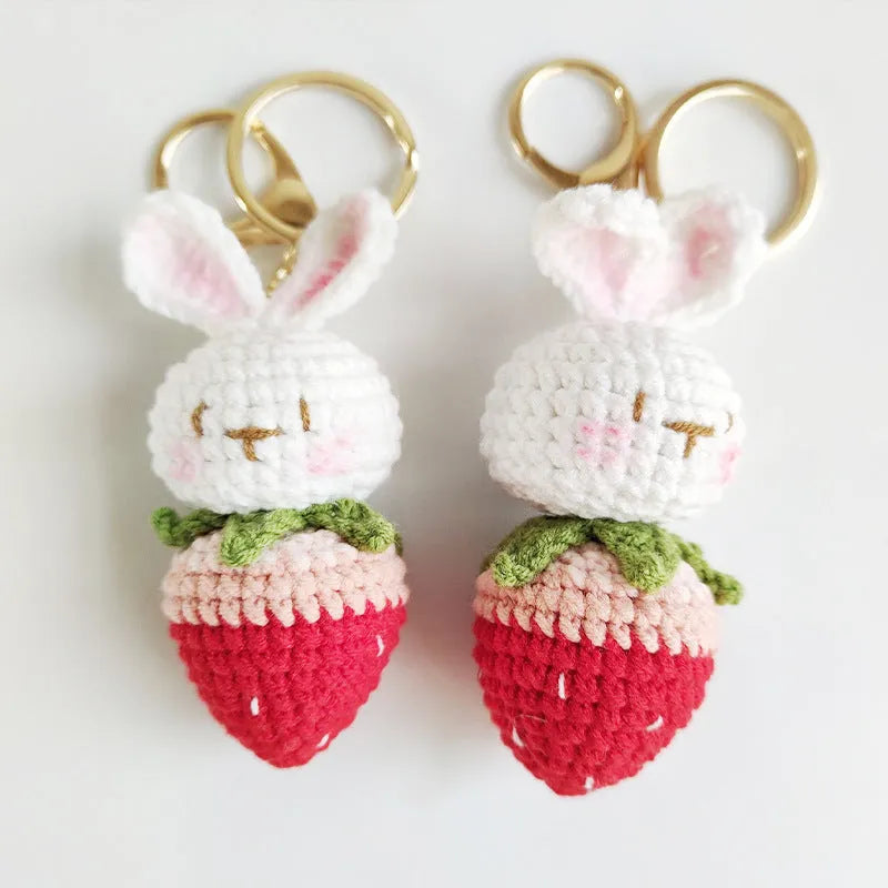 White hand-woven wire rabbit pendant with strawberry pattern attached to a key ring
