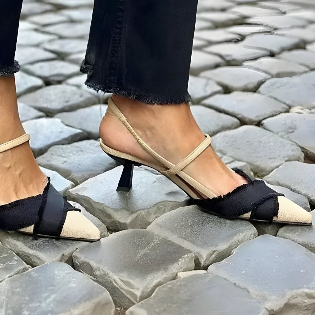Women's apricot and black colour block pointed toe stiletto sandals with a buckle strap.