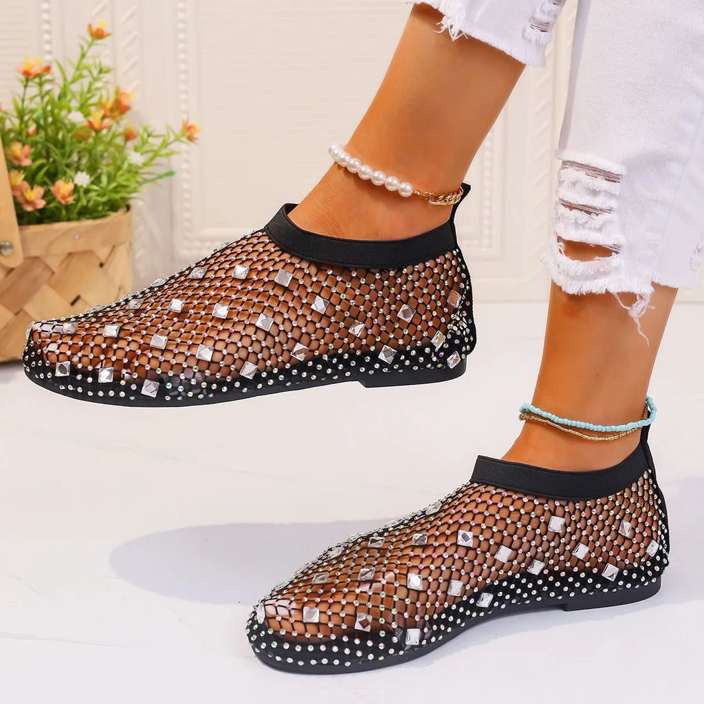 Women's flat sandals with colourful rhinestones on a mesh upper and a rubber sole.