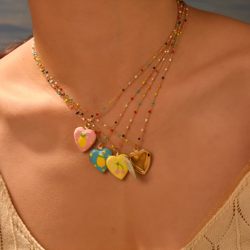 Stainless steel necklace with gold plated heart pendant featuring fruit design on adjustable chain