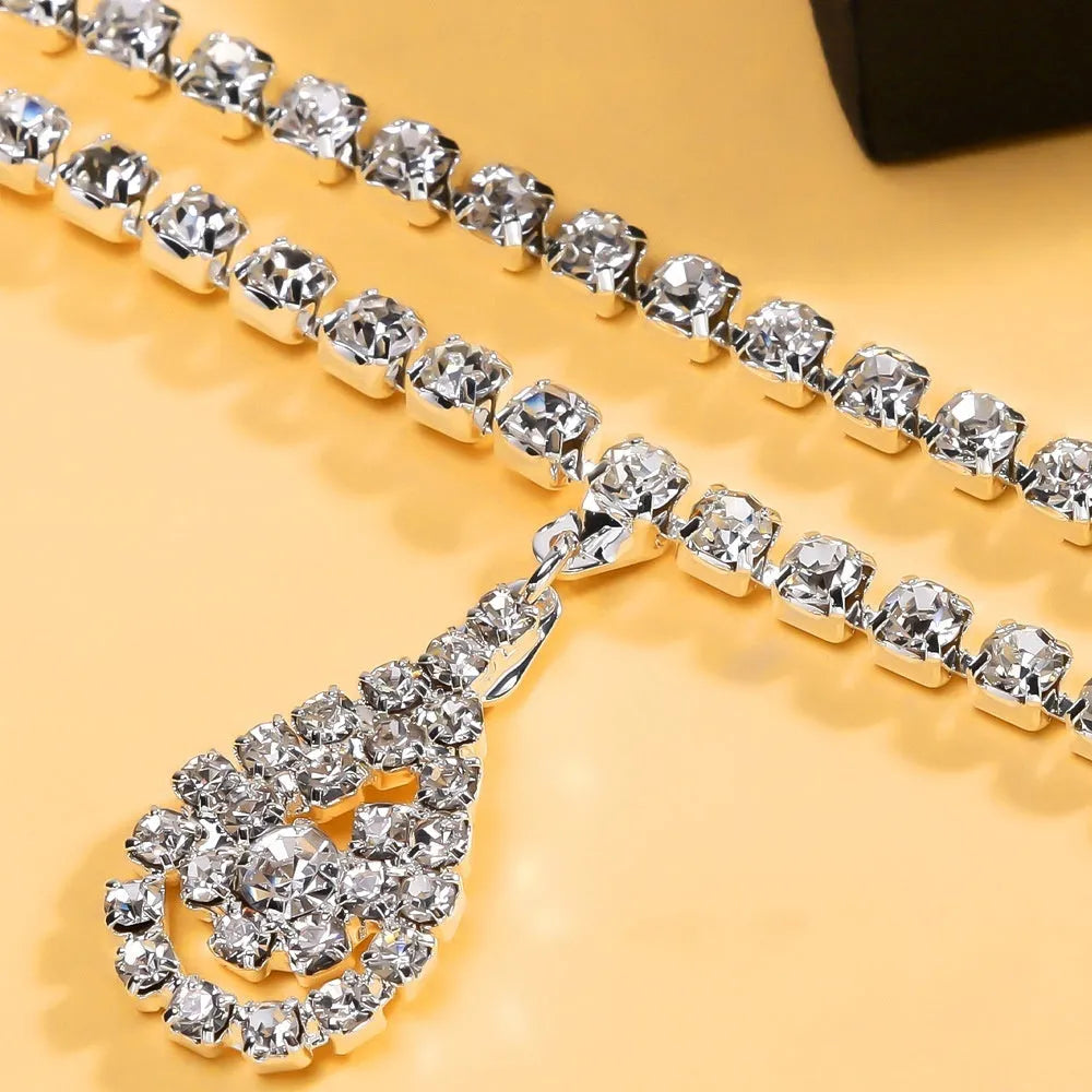 Gold waist chain with water drop pendant and rhinestone details, showing lobster clasp closure