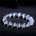 Women's white crystal pyramid bead bracelet with a Ruyi charm on a wrist.