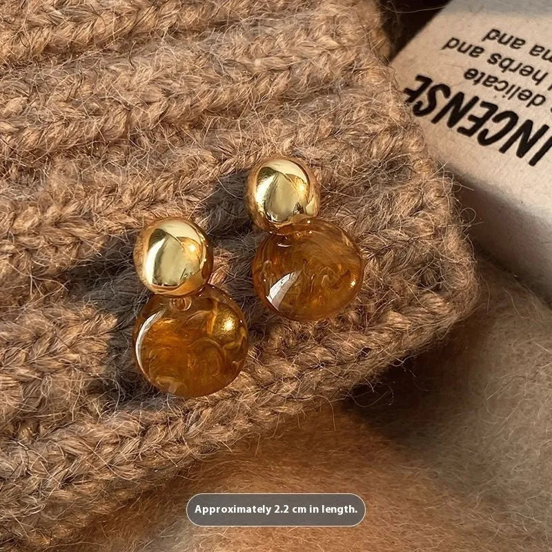 Three pairs of geometric alloy earrings with electroplated finishes in irregular amber, wafer round, and water drop tassel styles
