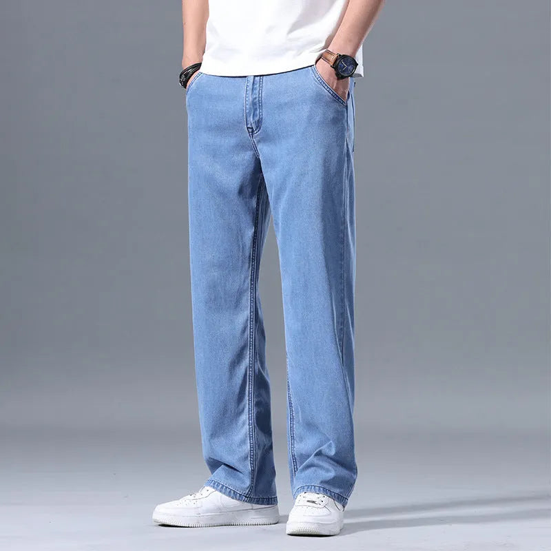 Men's light blue loose straight-leg lyocell jeans with a zipper fly on a neutral background.