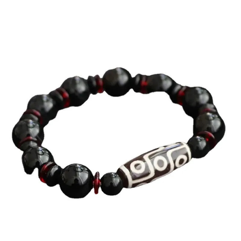 Black agate dzi bead bracelet with geometric beads and hand-woven construction