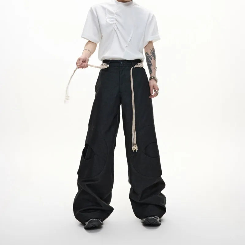 Men's dark blue straight-leg jeans showing heavy belt stitching, 3D cutting, zipper decoration, and a loose fit.