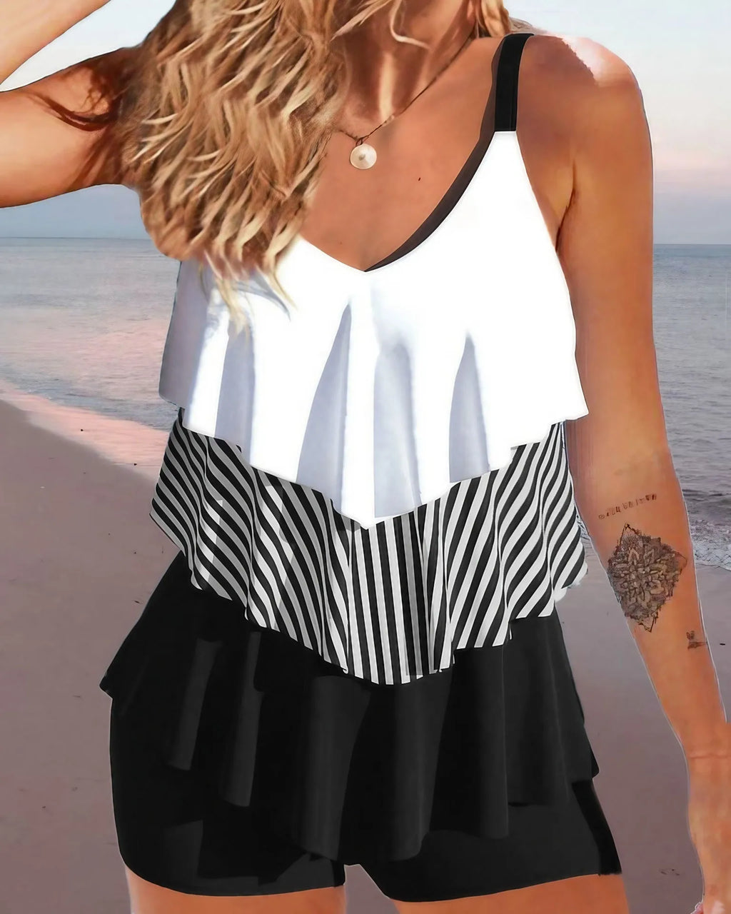 Women's sleeveless backless bikini with spaghetti straps and ruffle trim, shown in a solid colour.