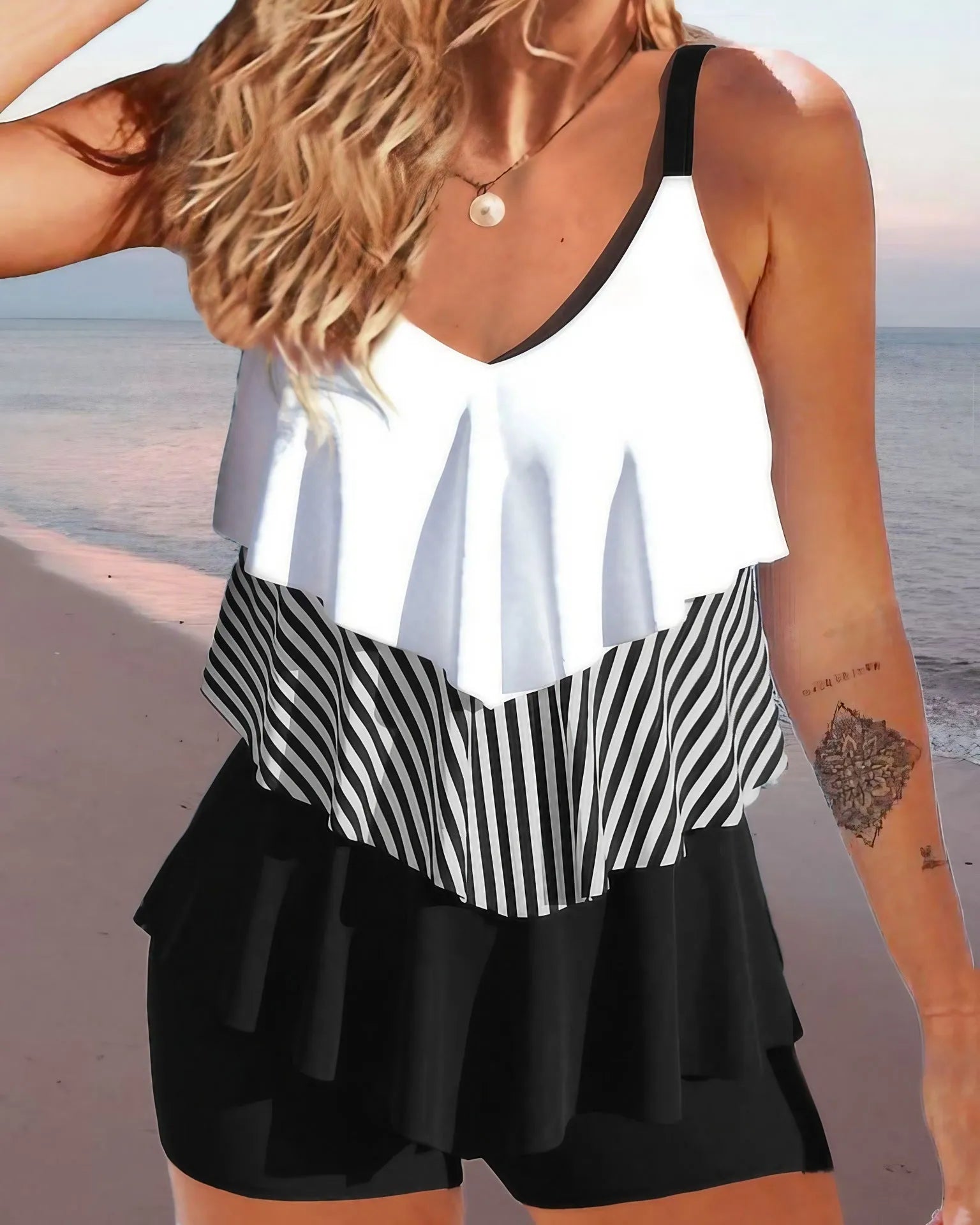 Women's sleeveless backless bikini with spaghetti straps and ruffle trim, shown in a solid colour.