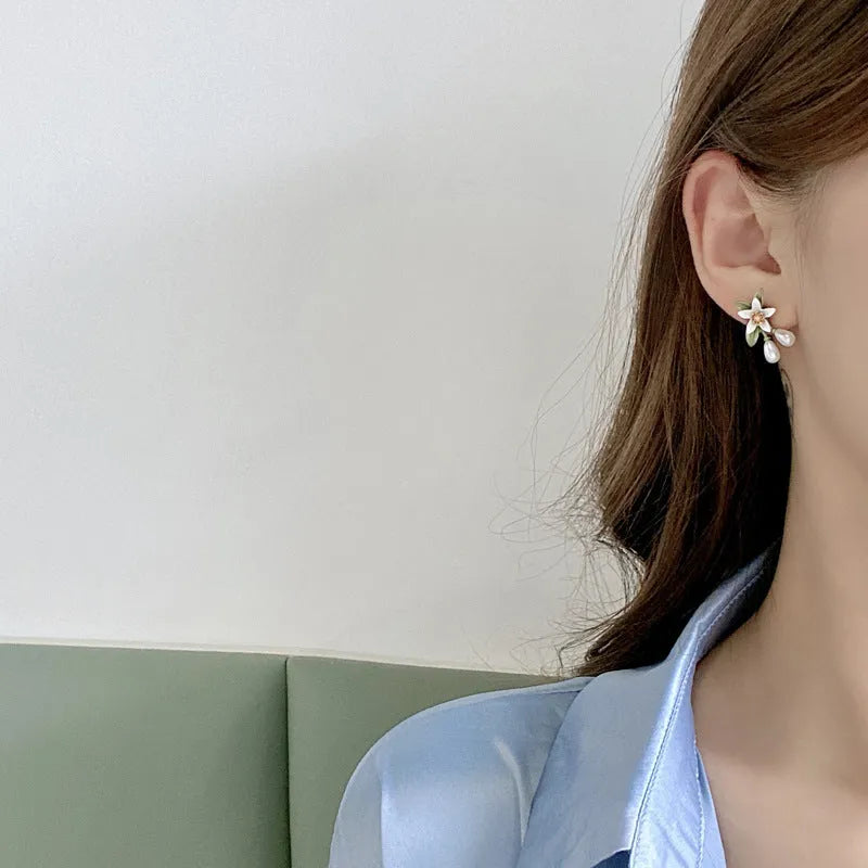 A pair of women's alloy flower-shaped clip-on earrings with contrasting sterling silver needle floral details.
