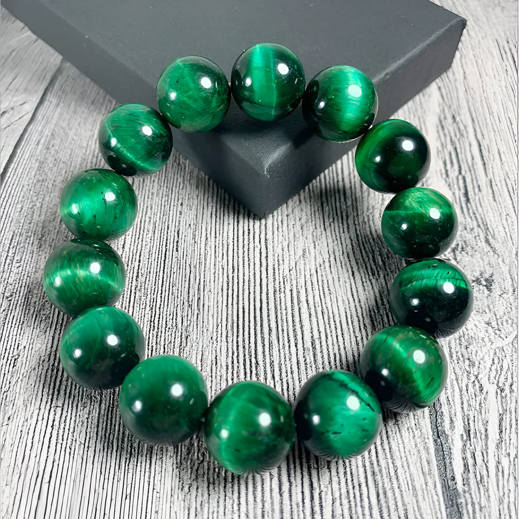 Polished green tiger eye stone beaded bracelet on a white background, showing geometric shaped beads.