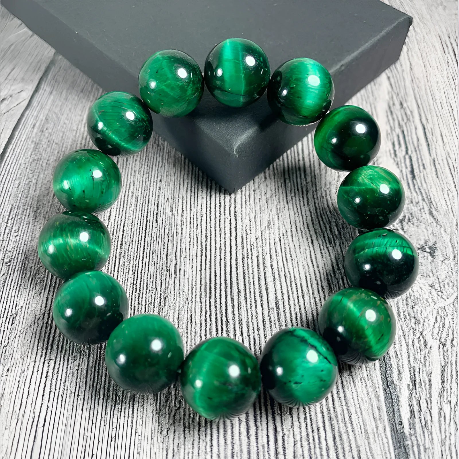 Polished green tiger eye stone beaded bracelet on a white background, showing geometric shaped beads.