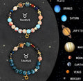 Set of twelve beaded bracelets with natural stone beads, each representing a different zodiac sign on an adjustable cord.