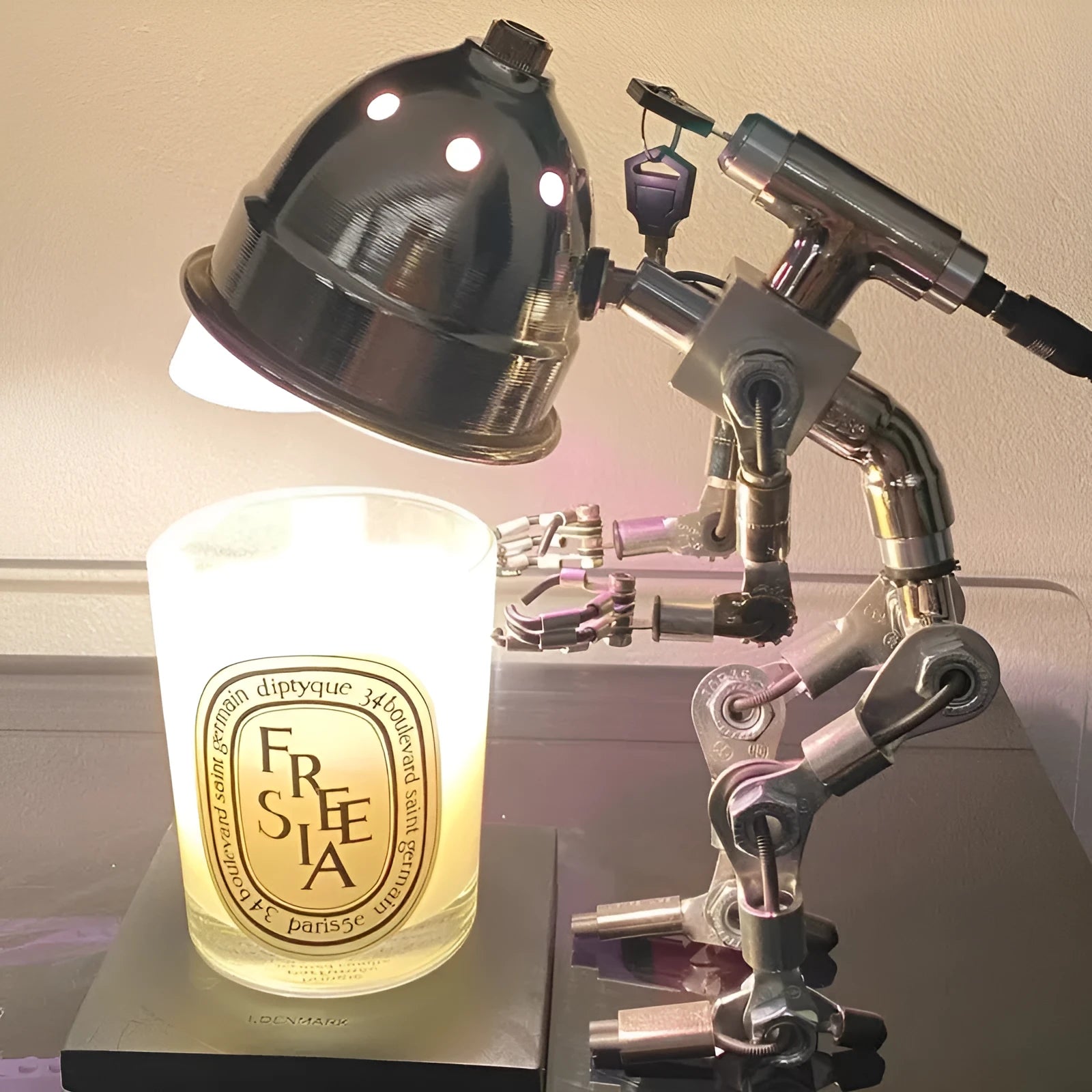Silver copper robot-shaped table lamp with atmospheric lighting on study desk