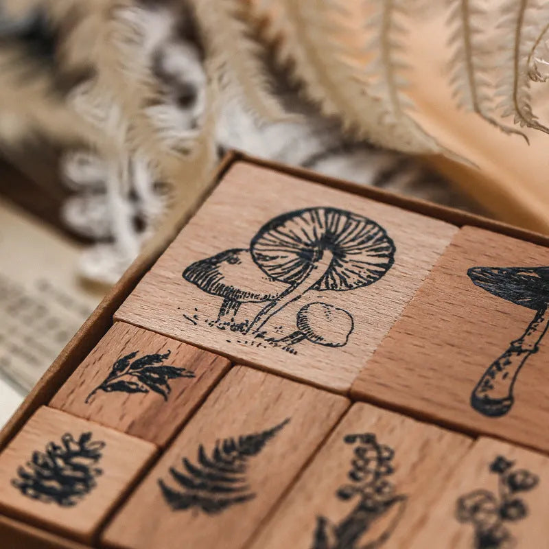 Wooden decorative stamp set with seven hand-carved botanical or celestial designs for paper crafts