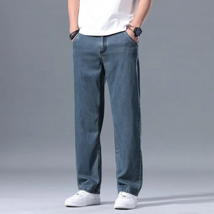 Men's light blue loose straight-leg lyocell jeans with a zipper fly on a neutral background.