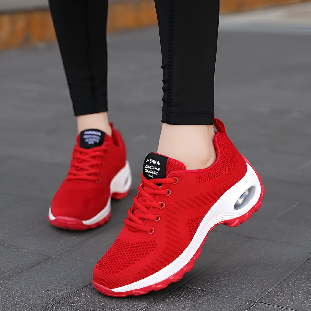 Women's red and black round toe lace-up mesh sneakers with low top and flat mid heel.