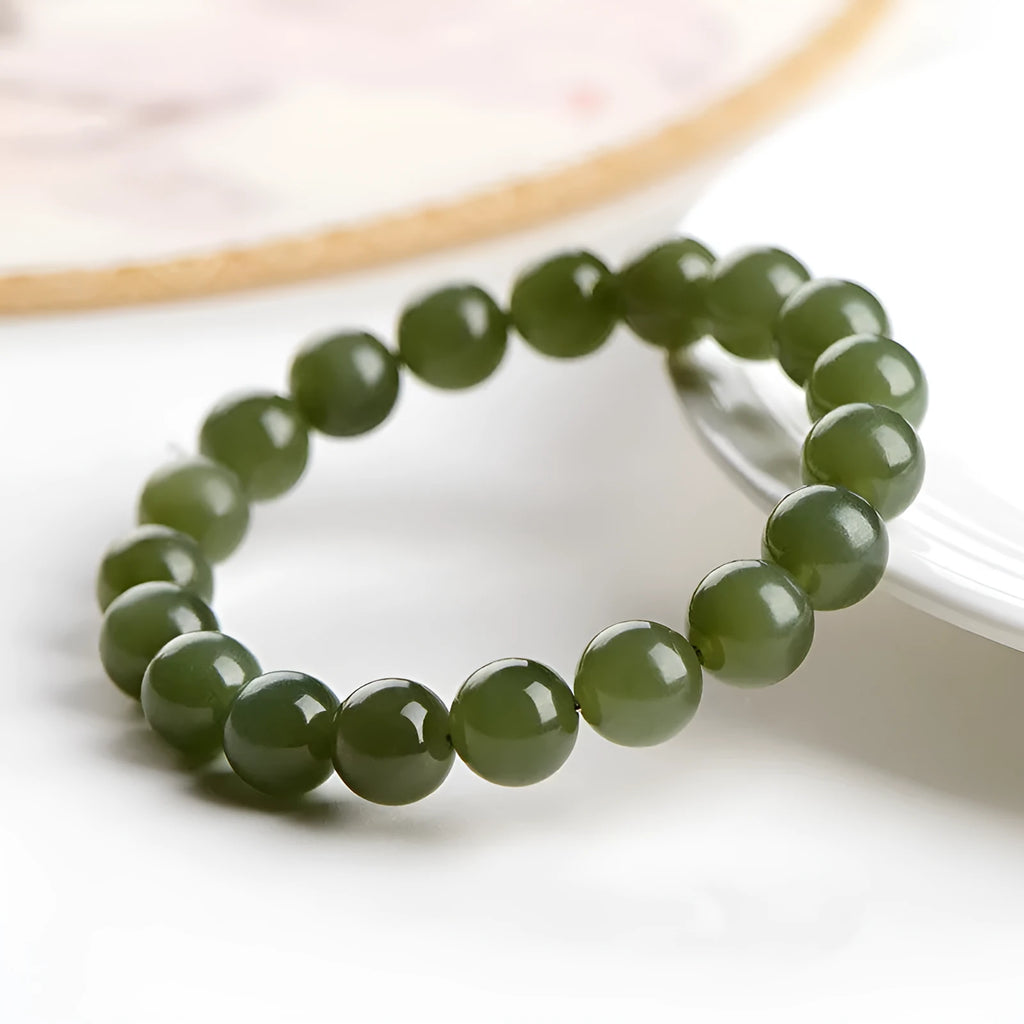 Polished Hetian jade ball bracelet on wrist, showing clear beads.