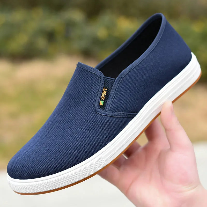 Men's black low-top canvas slip-on shoes with round toe and shallow mouth design on a white background.