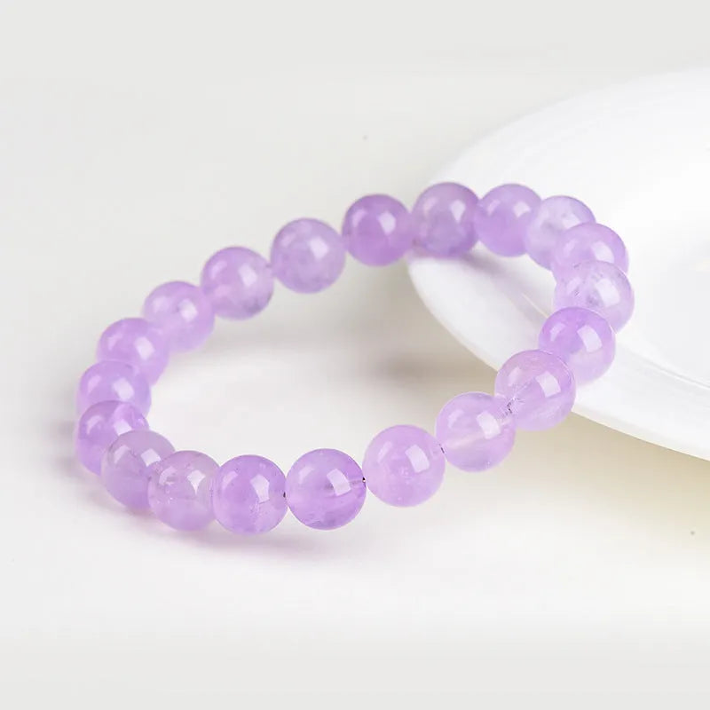 Light purple amethyst crystal bracelet with round beads and water ripple design on a wrist.