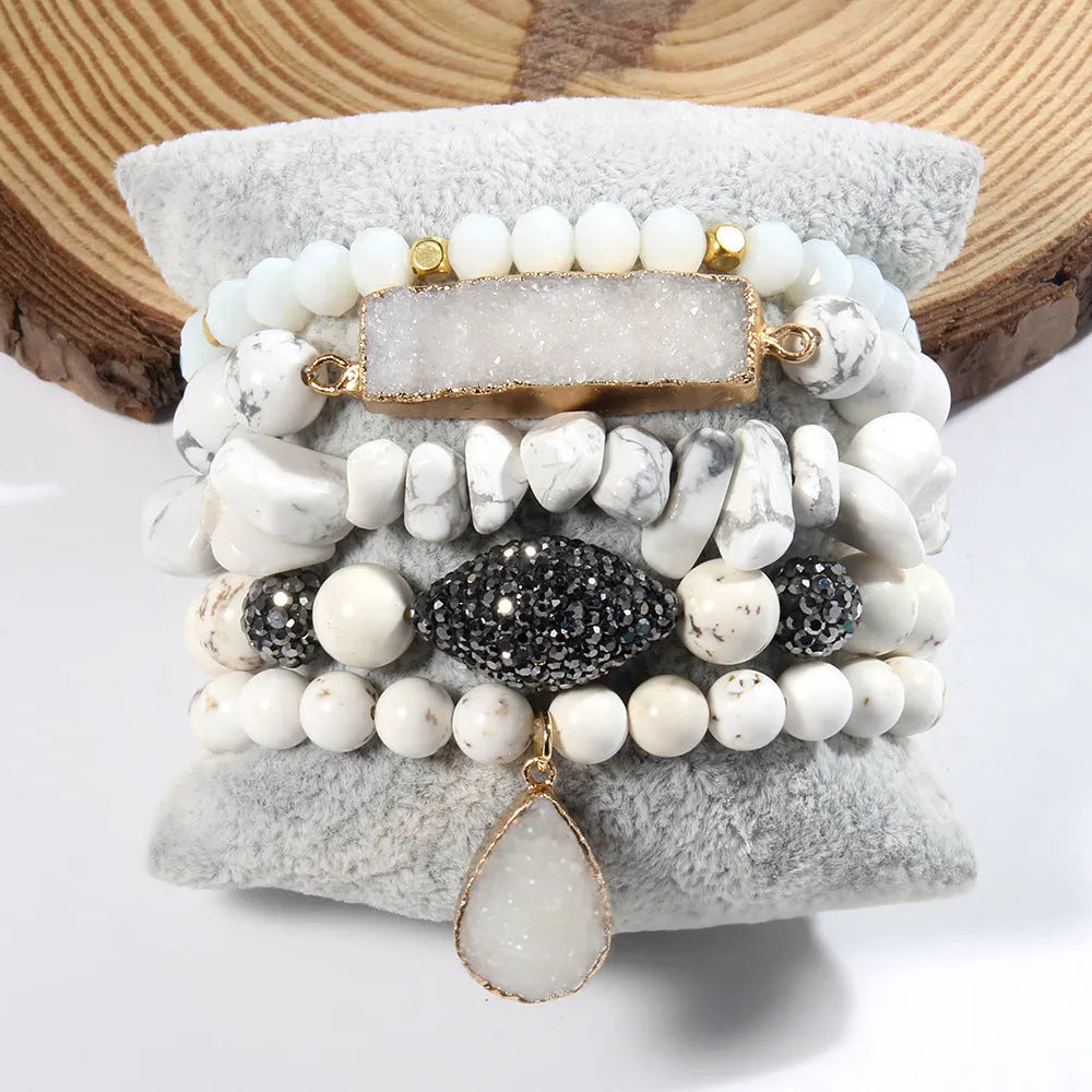 Set of five handmade stretch bracelets with glass, crystal, and hematite beads in irregular shapes on a neutral background