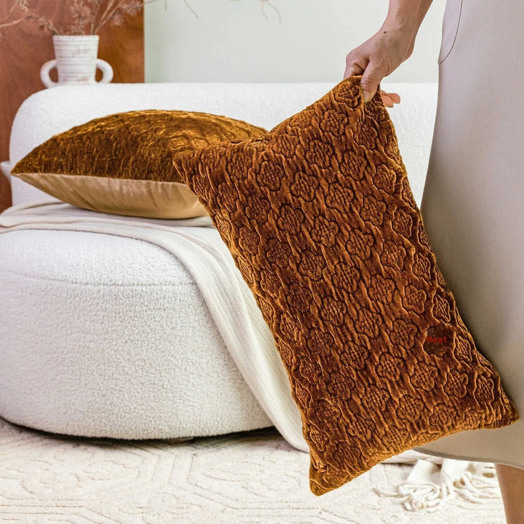 Brown gold antique quilted square cushion pillow on a sofa next to a green waist pillow.