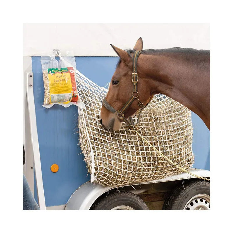 Black woven PE rope mesh feeding bag for horses hanging on a fence