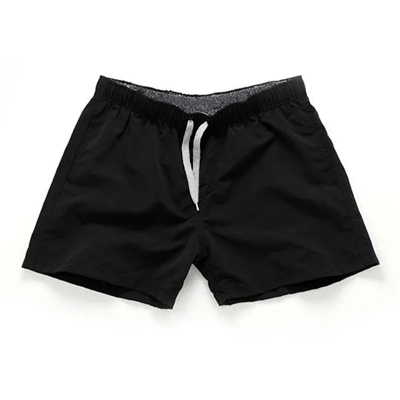 Men's straight-leg polyester beach shorts on a hanger, showing the classic fit and available in multiple solid colours.