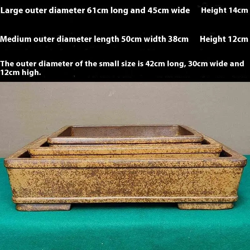Straight shallow rectangular Yixing Zisha flowerpot in purple sand clay on a ground surface.