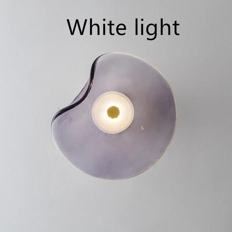 Round decorative wall lamp with glass shade in choice of cognac, light purple, or smoky grey finishes for bedroom lighting