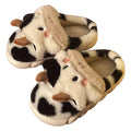 White and coffee coloured cow animal slippers for women with a plush exterior and non-slip sole.
