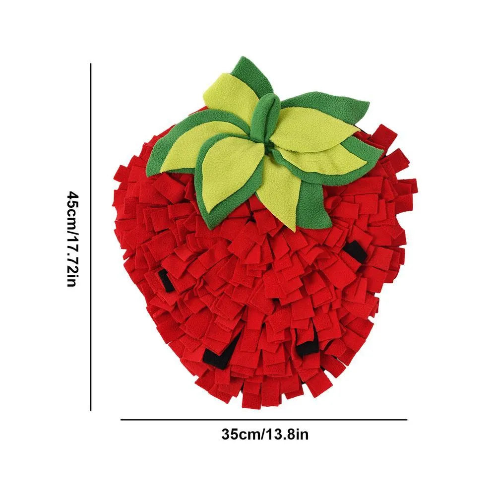 Red and green strawberry-shaped pet slow feeder snuffle mat on a floor